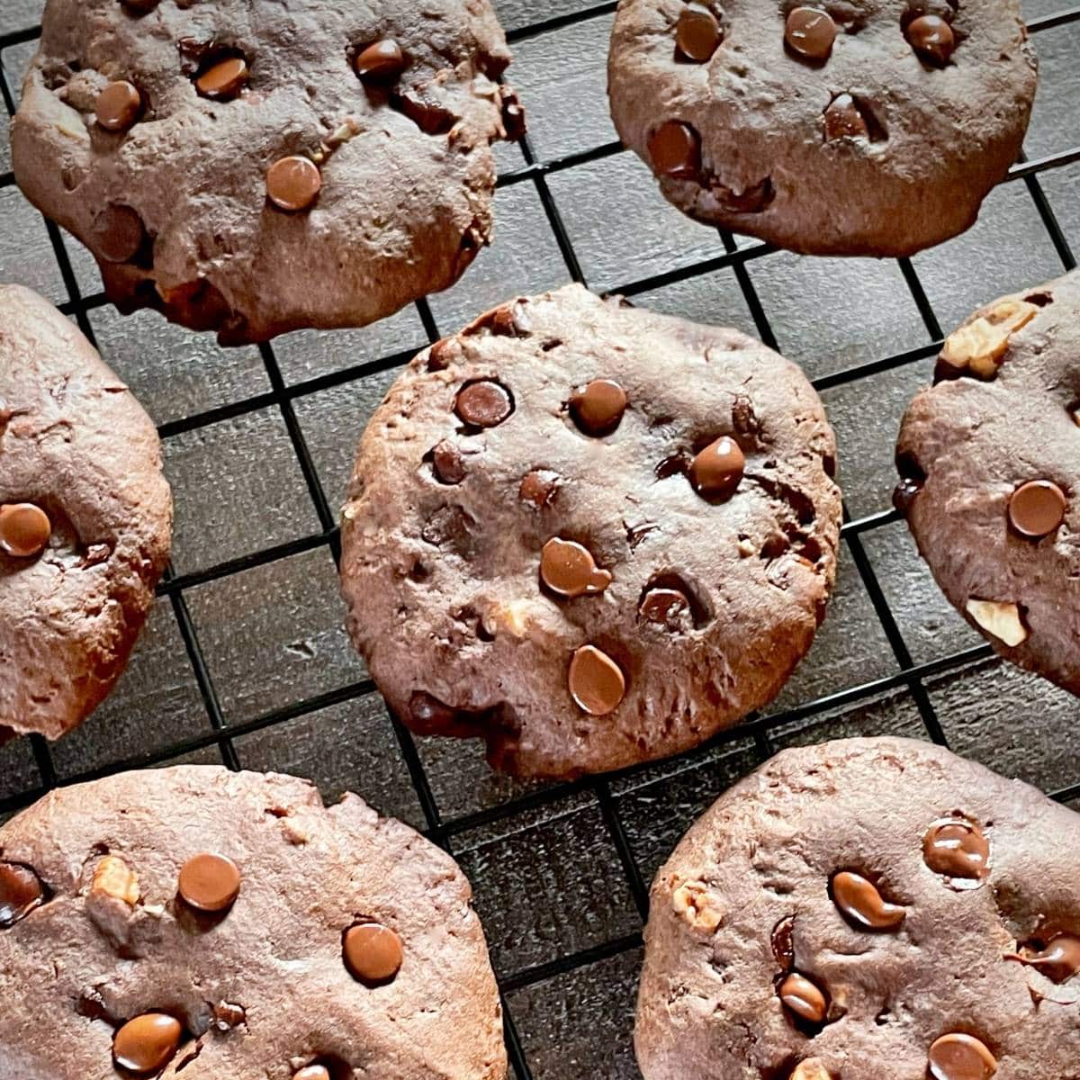 Chocolate protein cookies on a cooling rack.
