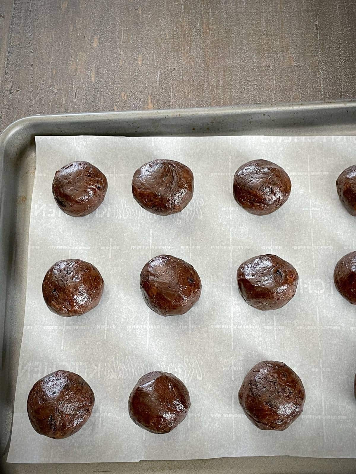 Truffle balls on a lined baking sheet.
