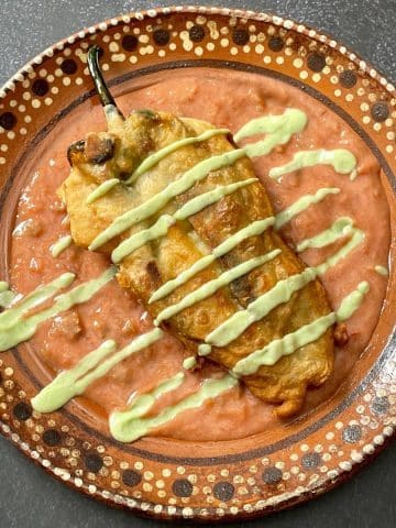 A chile relleno with crema sauce.