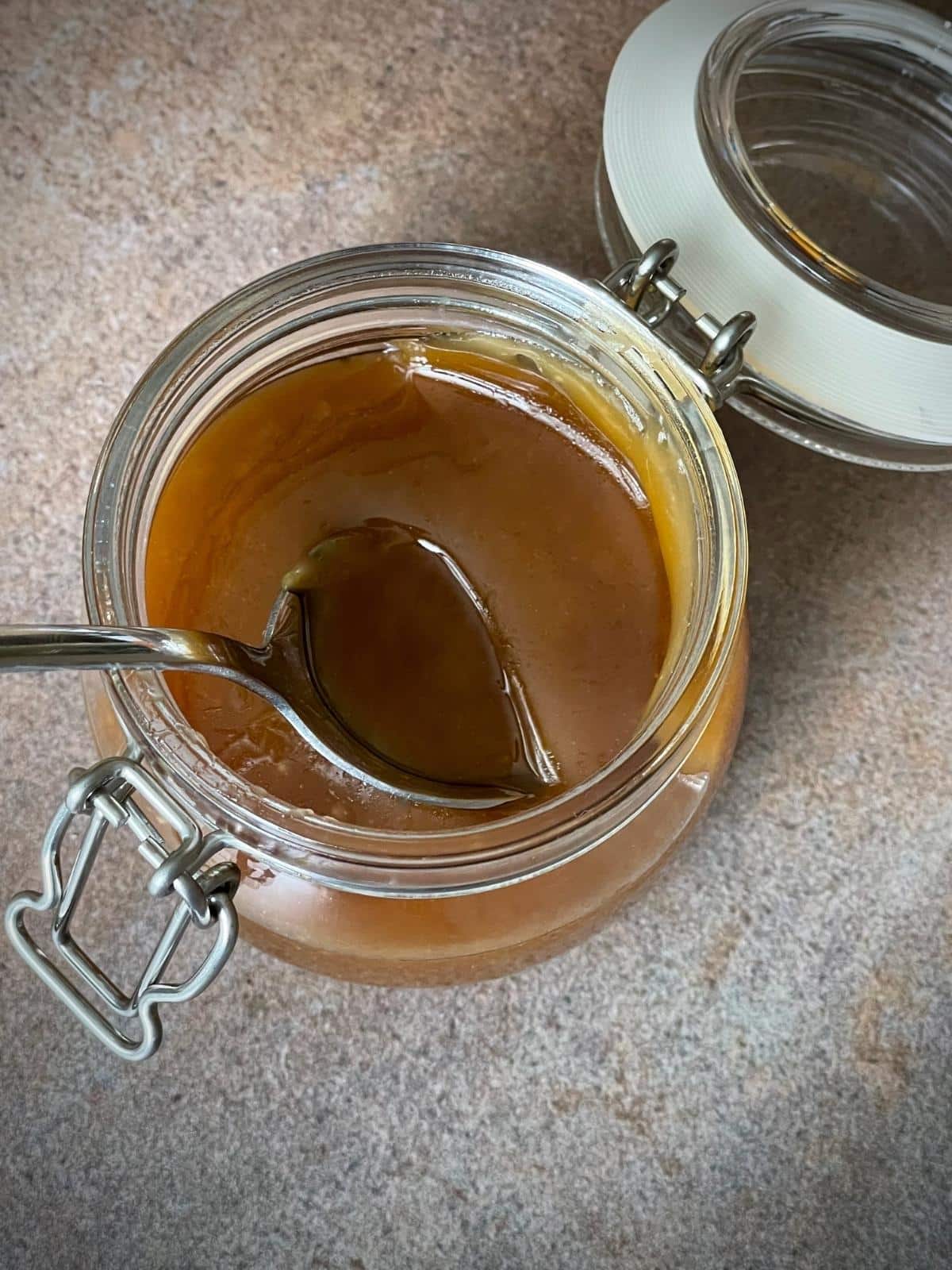 Butterscotch sauce with a spoon in it.