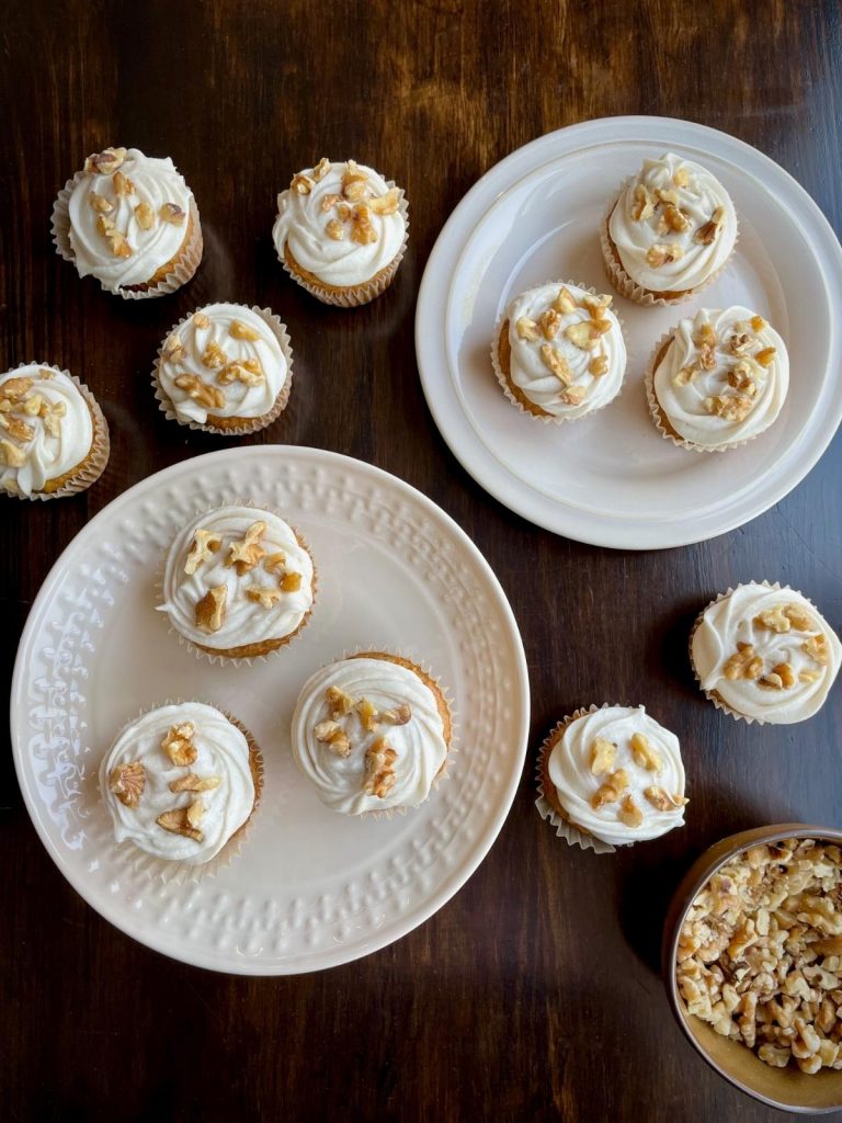 Frosted carrot cake cupcakes with nuts.