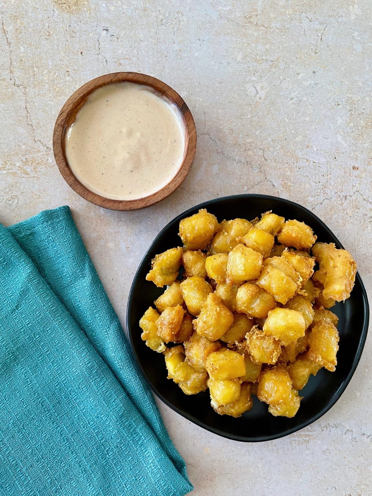 Vegan cheese curds with dipping sauce.