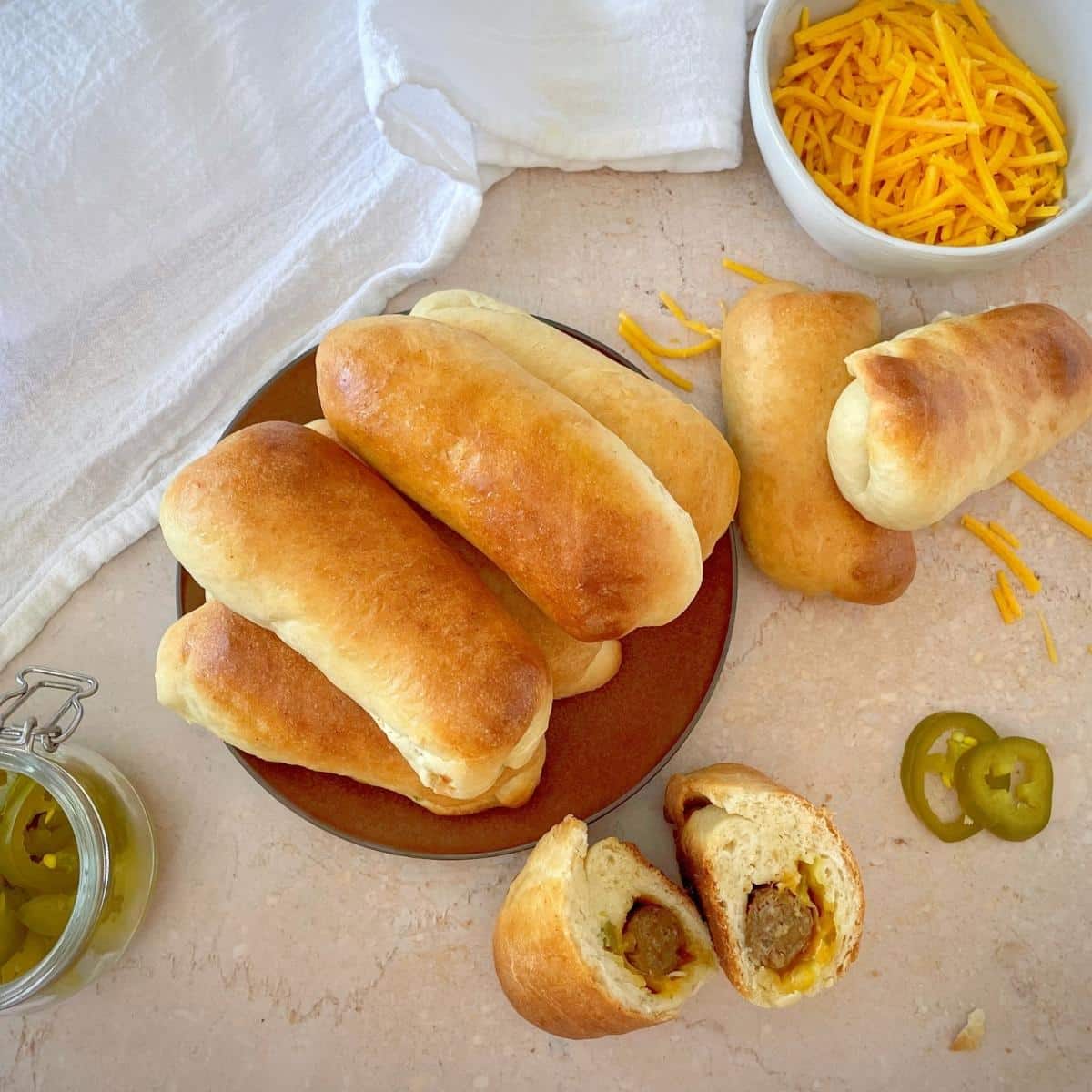 Vegan kolaches on a plate with cheese and jalapeños on the side.