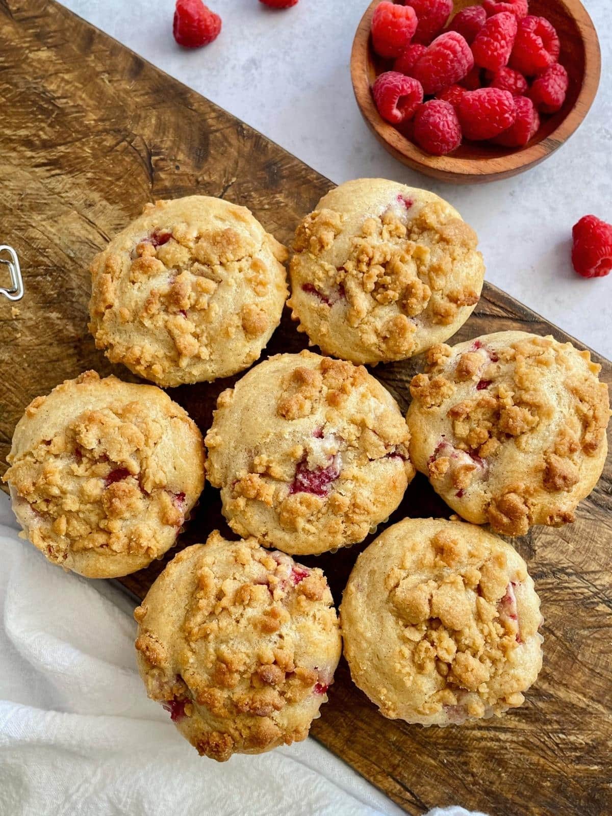 Raspberry muffins on a cutting board.