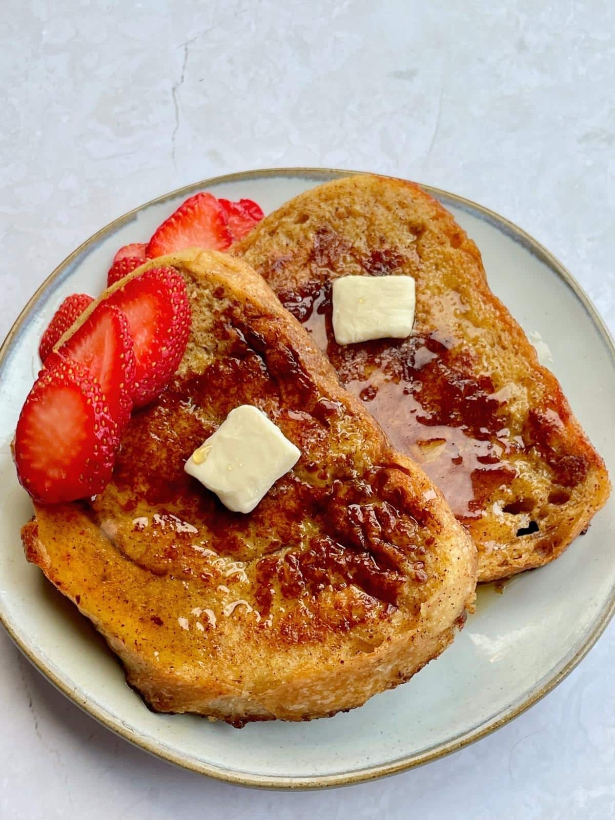 Vegan french toast with butter and fruit.