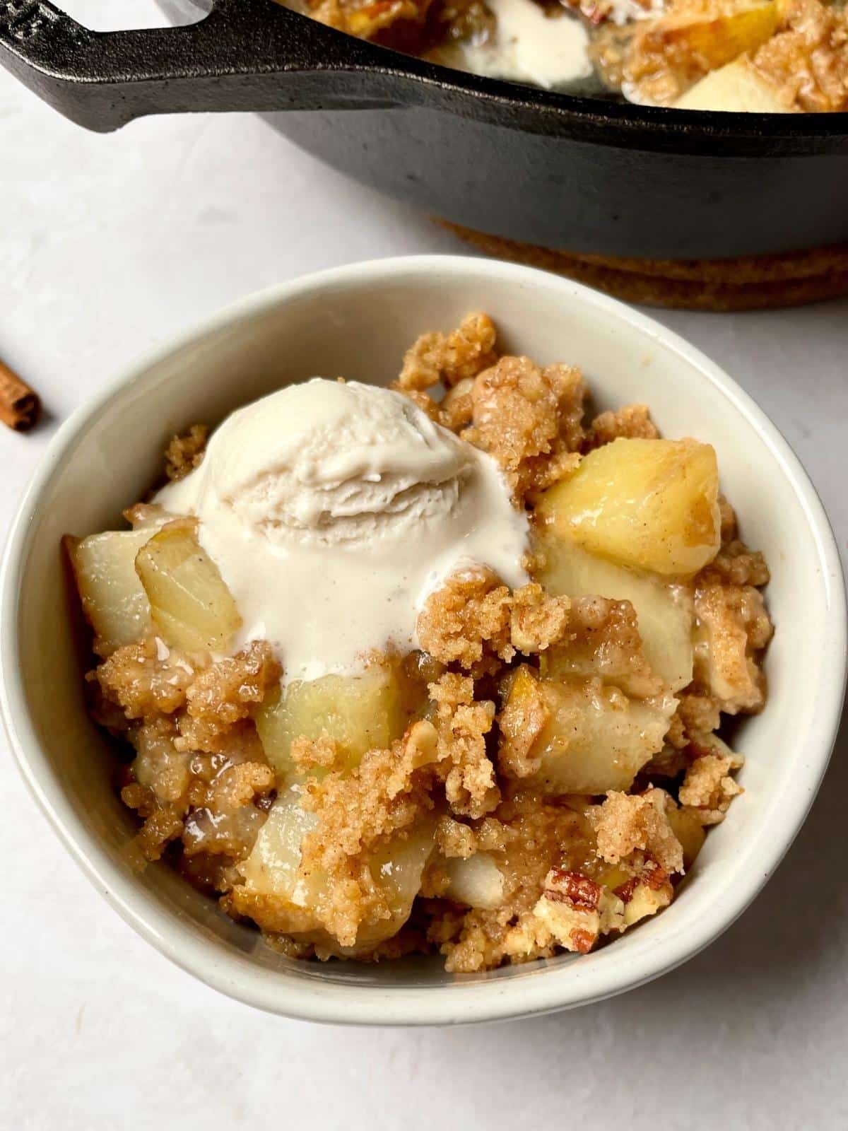 A bowl of pear crumble and vegan ice cream.