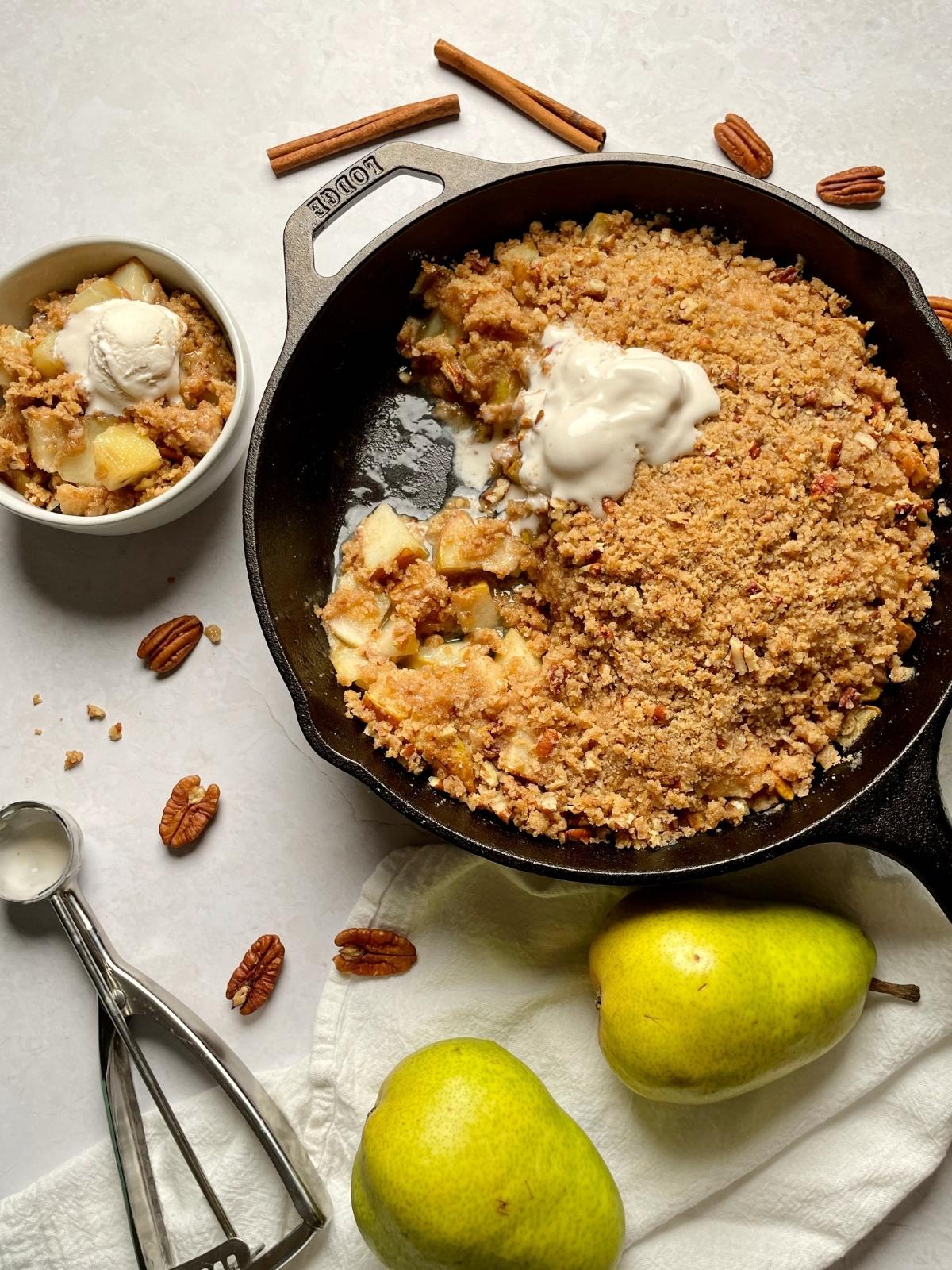 Serving pear crumble into a bowl.