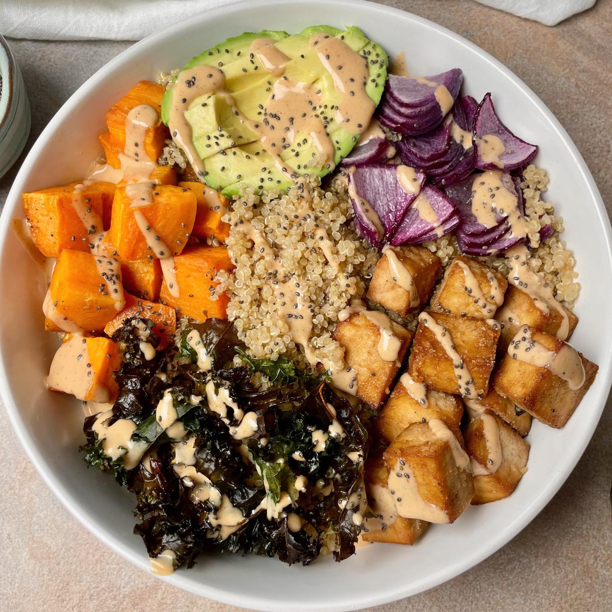 A bowl of tofu, quinoa, and vegetables.