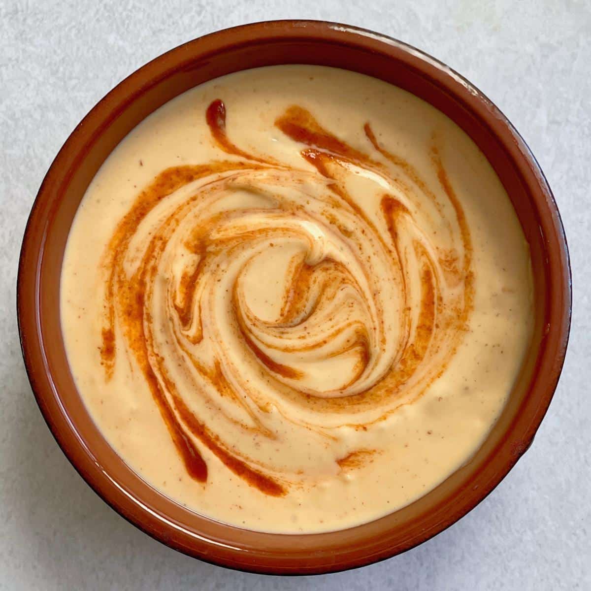 A bowl with vegan sriracha mayonnaise.
