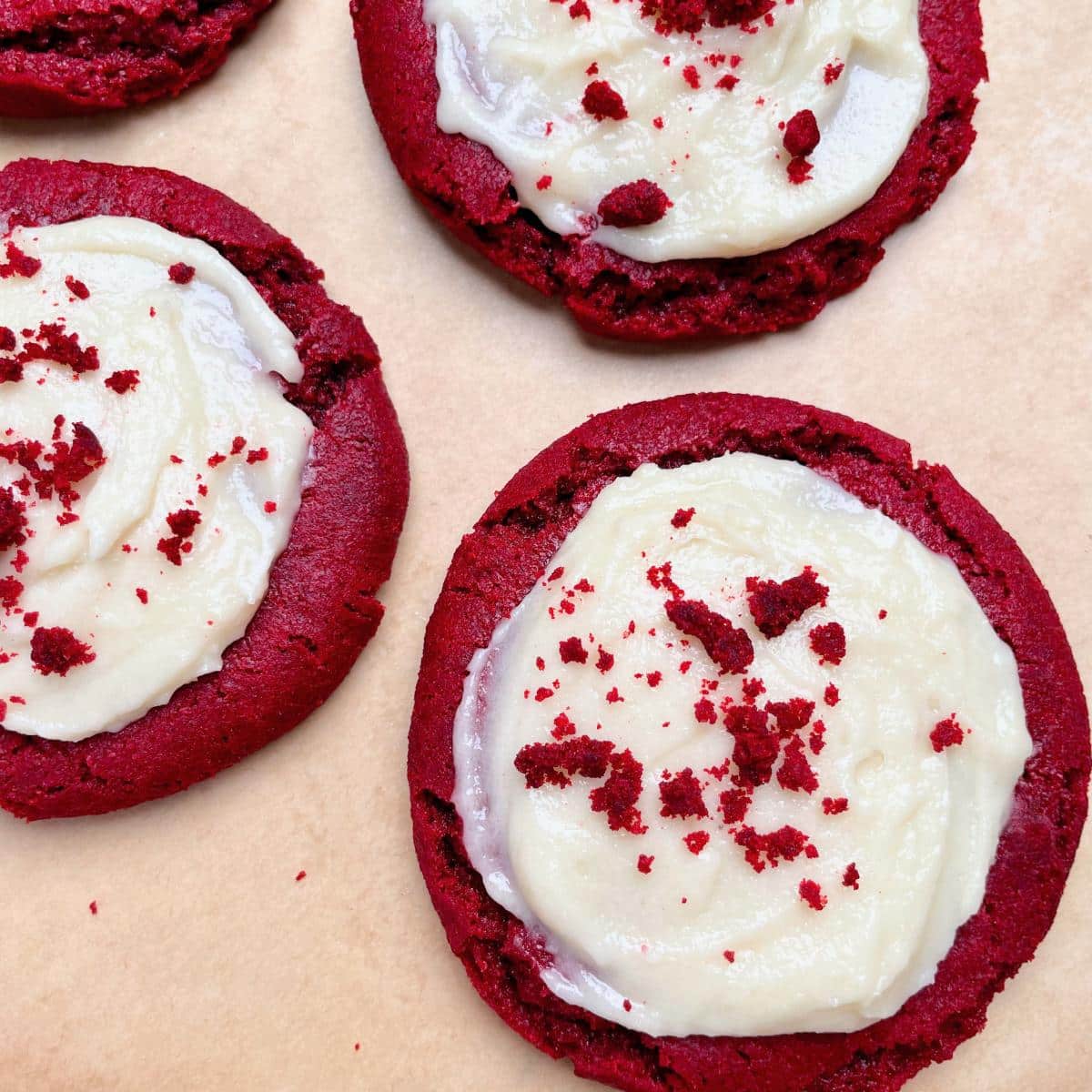 Red velvet cookies with vegan cream cheese frosting on top.