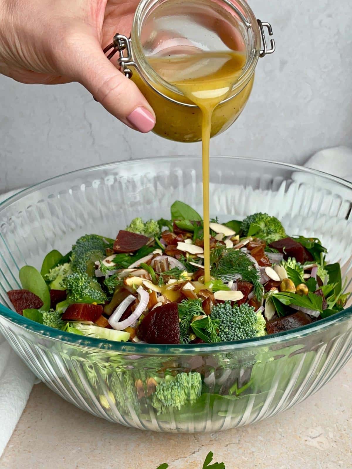 Pouring dressing over a salad.