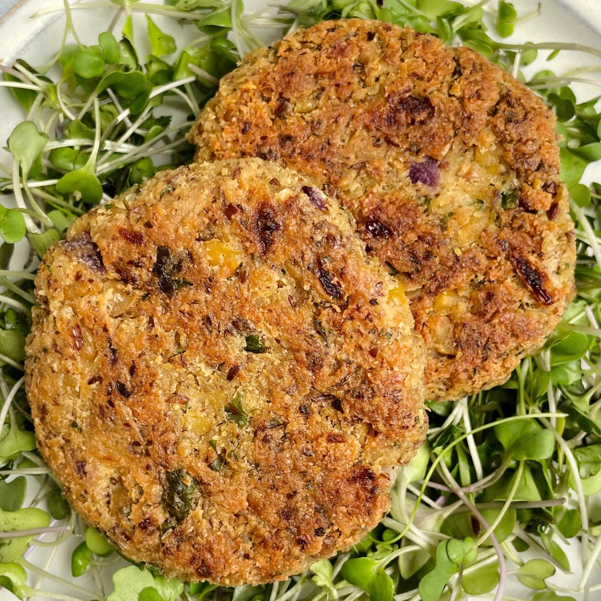 Vegan chickpea patties on a bed of microgreens.