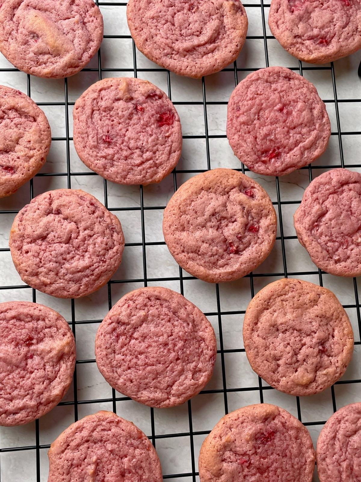 Strawberry cookies on a cooling rack.