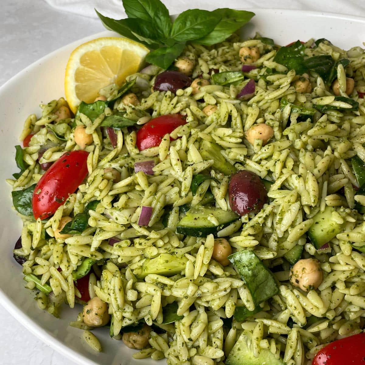 A plate with orzo pasta salad and pesto.