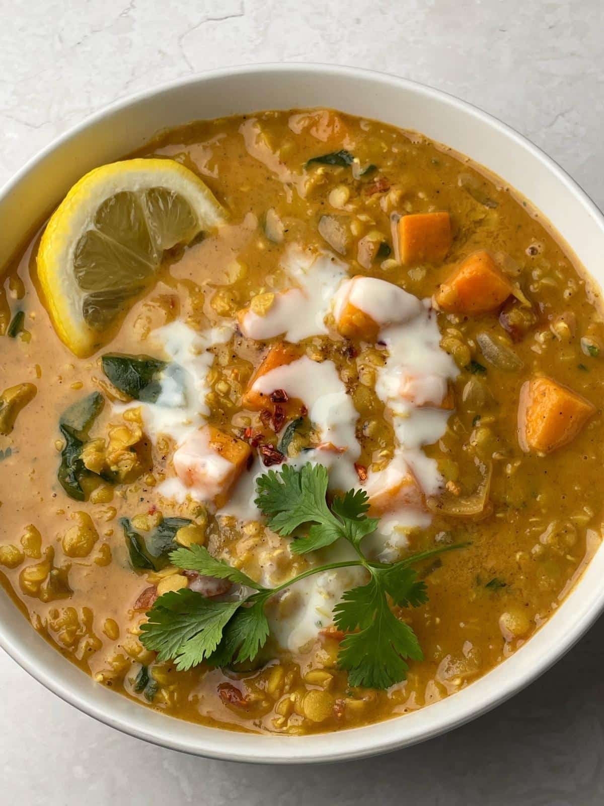 Red curry lentils garnished with lemon and red pepper.