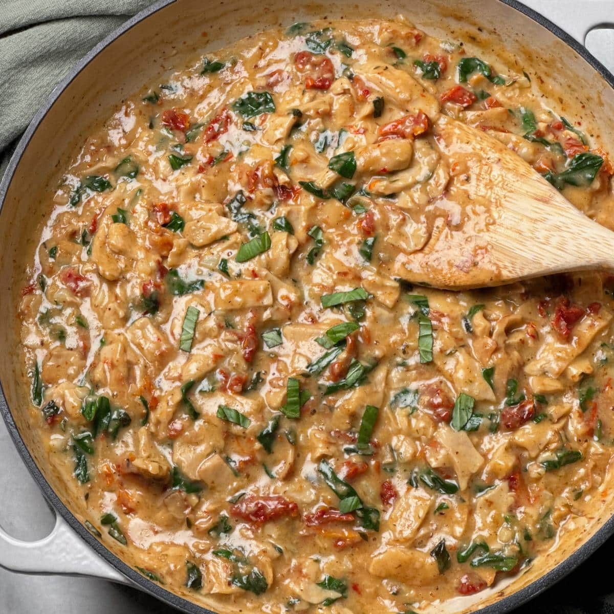 A pan filled with vegan marry me chicken in a sun-dried tomato cream sauce.