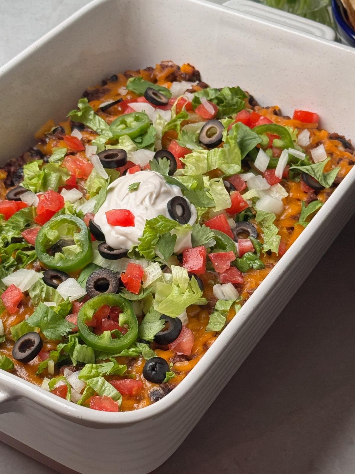 Fresh toppings over a baked taco casserole.
