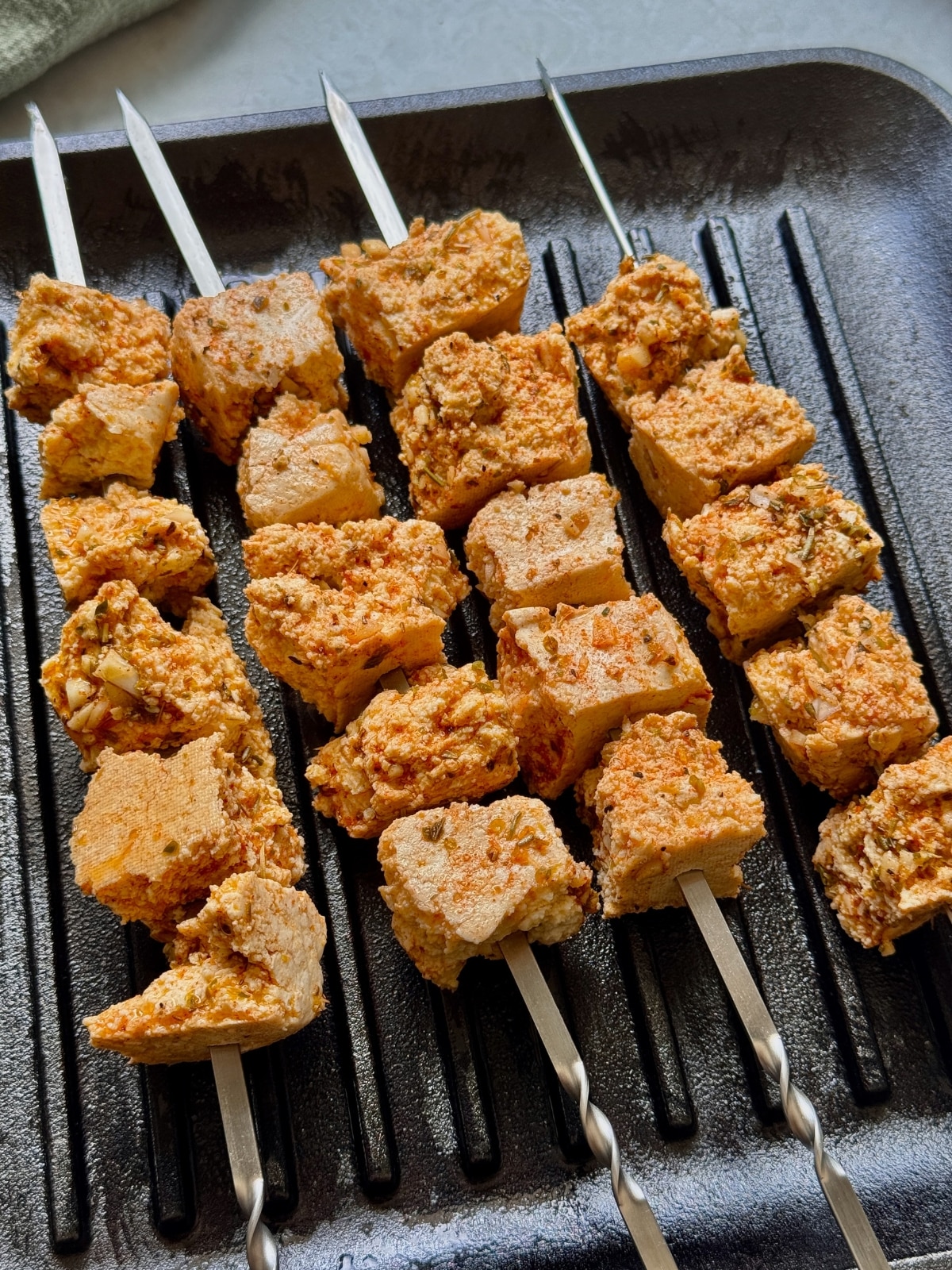 Cooking tofu skewers on a grill pan.
