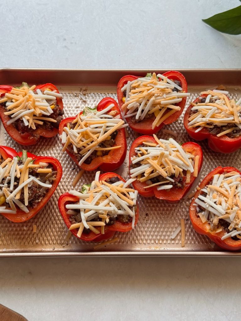 Peppers ready for the oven on a baking sheet.