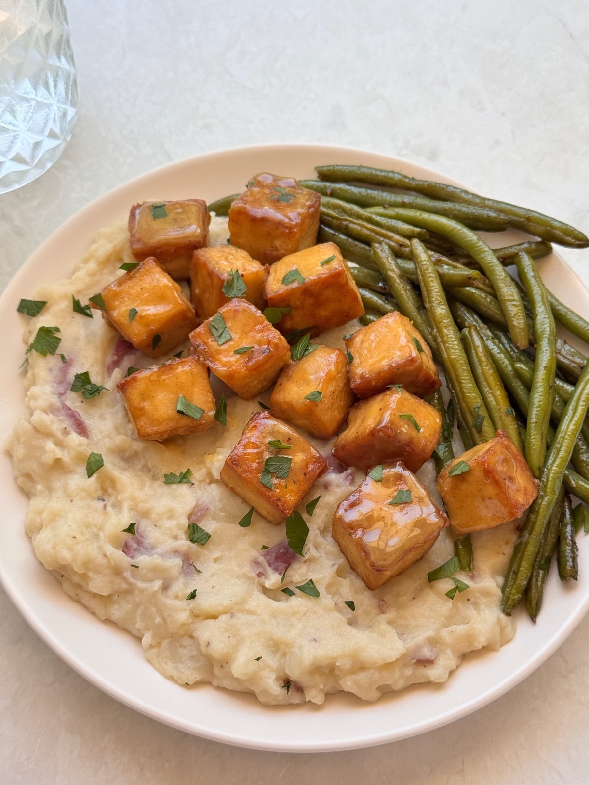 A plate with honey mustard tofu over vegetables.